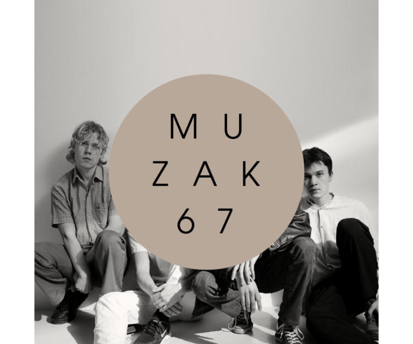 The image shows three people sitting on the floor. A large beige circle with the text "MUZAK 67" covers the center of the image. The picture is in black and white except for the beige circle.